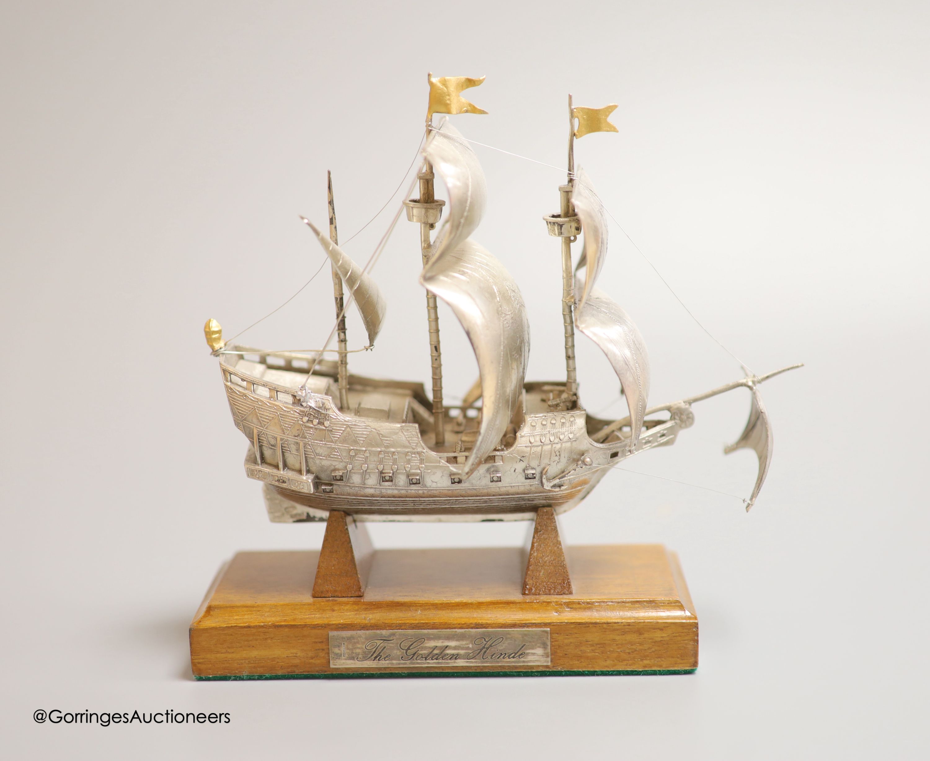 A modern Italian white metal (stamped 925) miniature model of the ship, 'The Golden Hind', (repairs), post 1968 mark, length 16cm, on a wooden stand